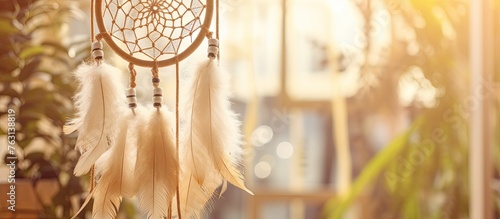 A dream catcher hangs from a wooden window sleeve in a room, surrounded by sports equipment, sleeveless shirts, font jewellery, fashion accessories, glass, and eyewear photo