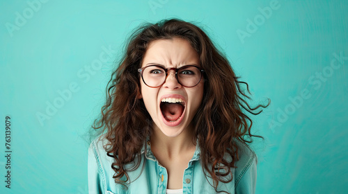 The young emotional angry woman screaming on pastel blue background