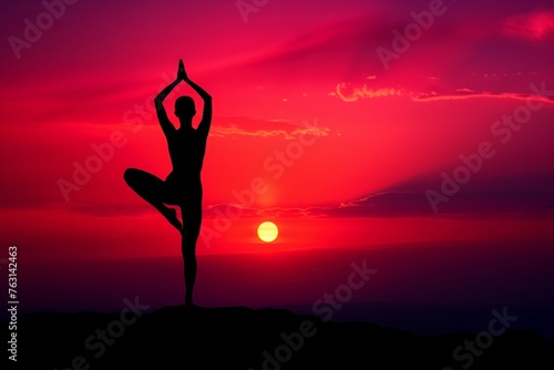 Serene yoga tree pose silhouette gracing a dramatic red sunset horizon
