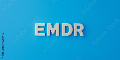 Letters EMDR written on blue background. Eye Movement Desensitization and Reprocessing psychotherapy treatment concept.