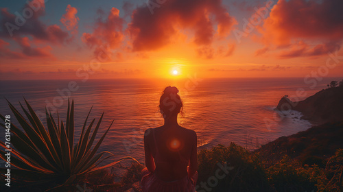 Photo taken from behind of a woman watching the sunset. Panoramic landscapes photography