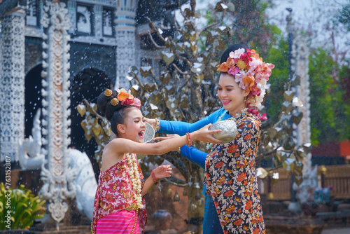 Songkran festival . Pretty Asian women playing with water-splashing Songkran. Beautiful Thai traditional dress costumes according to Thai culture to celebrate of the people Thailand New Year.