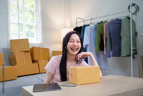 Young start up online business SME beautiful woman female Asian working writing on box for prepare shipping product to customer, Shipping shopping online, SMW working with box at home photo