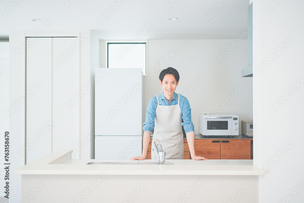 キッチンに立つエプロン姿の男性 キッチンに立つエプロン姿の男性