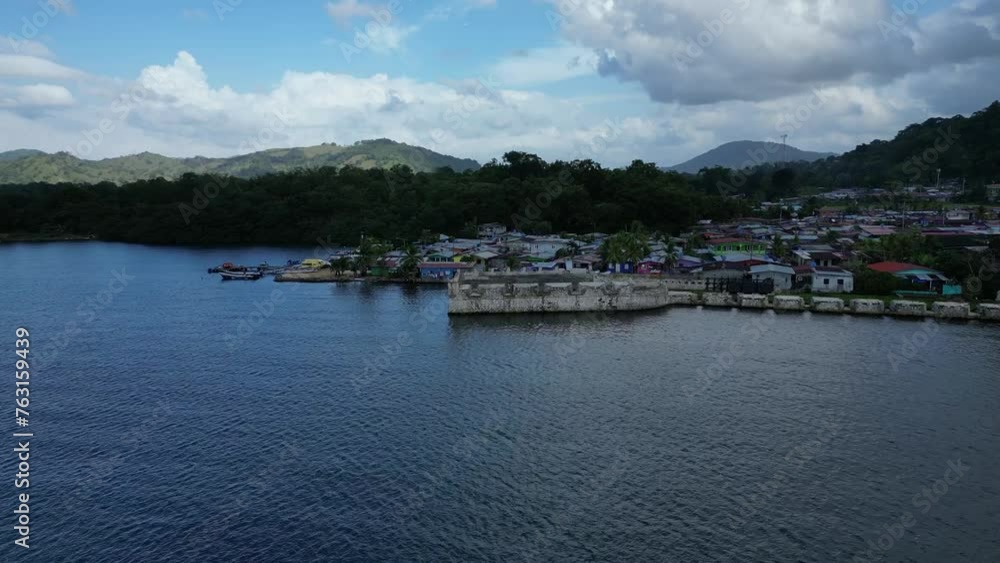 Aerial view of Portobello Town with green mountain and waterfront under cloudy sky in Panama Aerial view of Portobello Town with green mountain and waterfront under cloudy sky in Panama