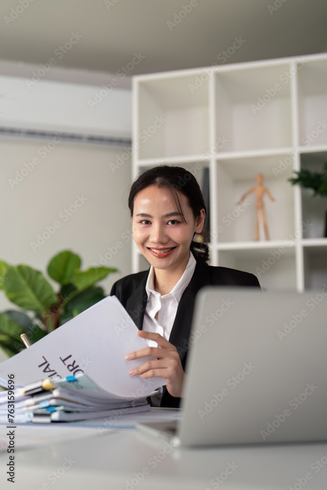 Young business woman asian or employee accounting bookkeeping documents checking financial data or marketing report working in office with laptop. Paperwork management Young business woman asian or employee accounting bookkeeping documents checking financial data or marketing report working in office with laptop. Paperwork management