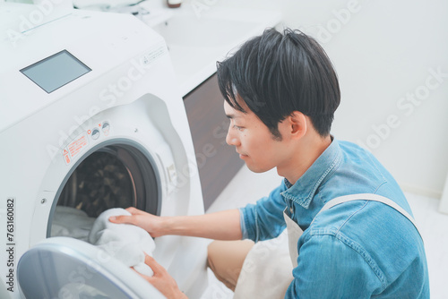 洗濯をするエプロン姿の男性