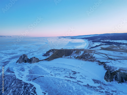 Beautiful winter landscape with mountains and Lake Baikal in Siberia at dawn. Natural background with copy space. Aerial view.