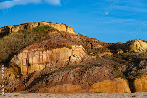 Multicolored sandstone rocks in the Almagreira beach in the Peniche area of the Center region of Portugal at sunset. photo