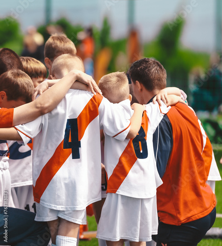 Kids With Coach in Sports Team. Friends on a Soccer Team. Male Football Players Huddling Together in a Circle Before a Match