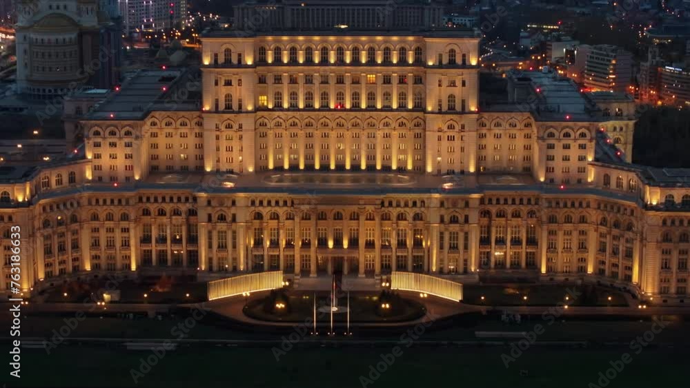 Aerial drone view of illuminated Palace of the Parliament in Bucharest downtown in the evening. Multiple districts around. Romania Aerial drone view of illuminated Palace of the Parliament in Bucharest downtown in the evening. Multiple districts around. Romania