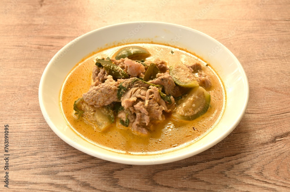 spicy boiled slice pork meat with eggplant in coconut milk green curry soup on plate spicy boiled slice pork meat with eggplant in coconut milk green curry soup on plate
