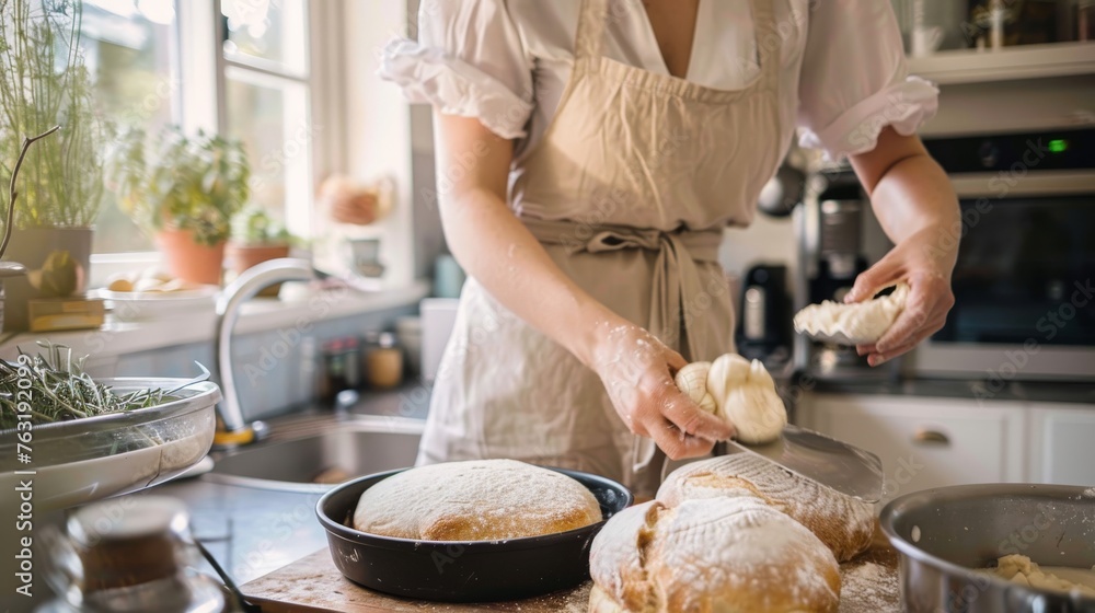 Person in apron shaping dough for artisan bread on a well-floured kitchen counter, with a warm, homey atmosphere.