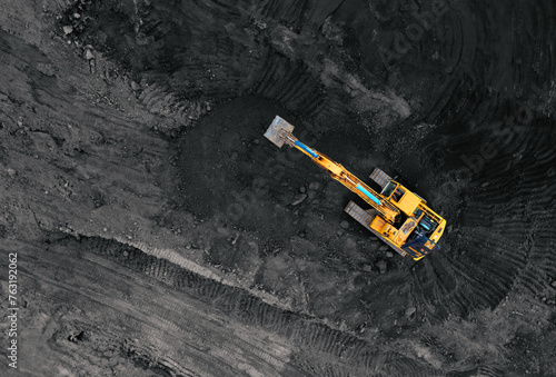 Coal mining in an open pit. Mining excavator loads coal in haul truck in quarry. Excavator digging in an open pit coal mine. Tipper truck hauling minerals from open-pit. Heavy machinery in opencast. photo