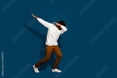 Full length photo of good mood cheerful man wear white sweater dancing having fun empty space isolated dark blue color background