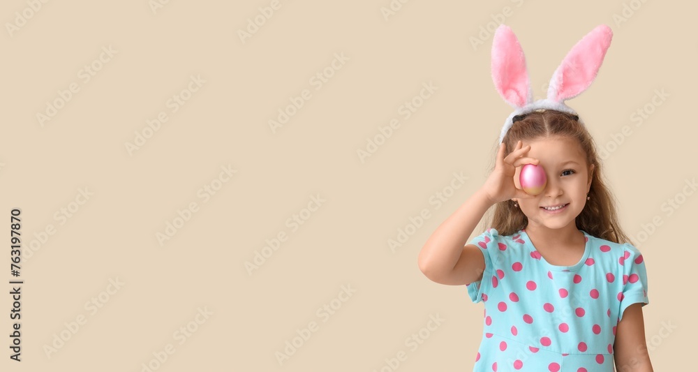 Cute little girl in bunny ears and with Easter egg on light background with space for text