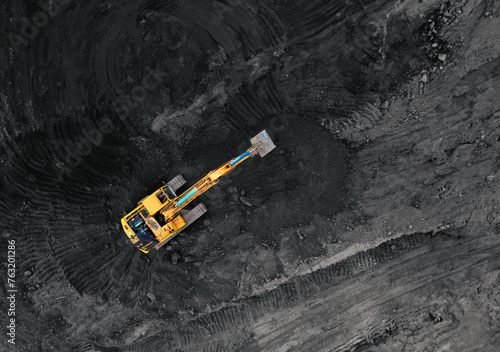 Coal mining in an open pit. Mining excavator loads coal in haul truck in quarry. Excavator digging in an open pit coal mine. Tipper truck hauling minerals from open-pit. Heavy machinery in opencast.