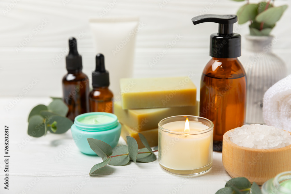 Beautiful spa composition on a wooden background with eucalyptus leaves. Beauty and fashion spa concept with body cream, scrub, mask, essential oil and sea salt.Cosmetic product. Copy space. Beautiful spa composition on a wooden background with eucalyptus leaves. Beauty and fashion spa concept with body cream, scrub, mask, essential oil and sea salt.Cosmetic product. Copy space.