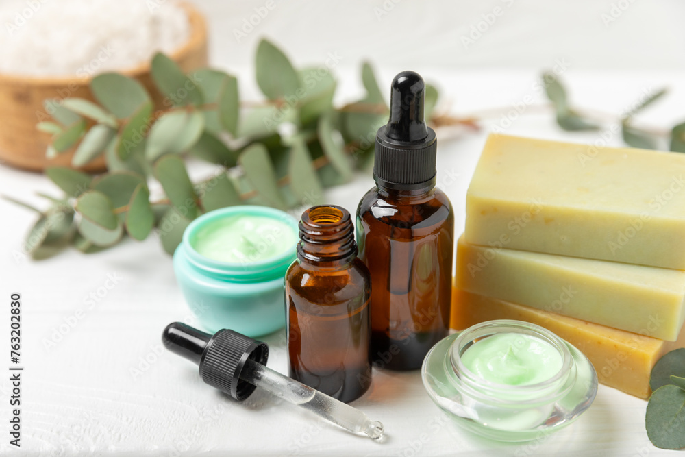 Beautiful spa composition on a wooden background with eucalyptus leaves. Beauty and fashion spa concept with body cream, scrub, mask, essential oil and sea salt.Cosmetic product. Copy space. Beautiful spa composition on a wooden background with eucalyptus leaves. Beauty and fashion spa concept with body cream, scrub, mask, essential oil and sea salt.Cosmetic product. Copy space.