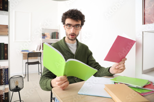 Shocked male student studyi...