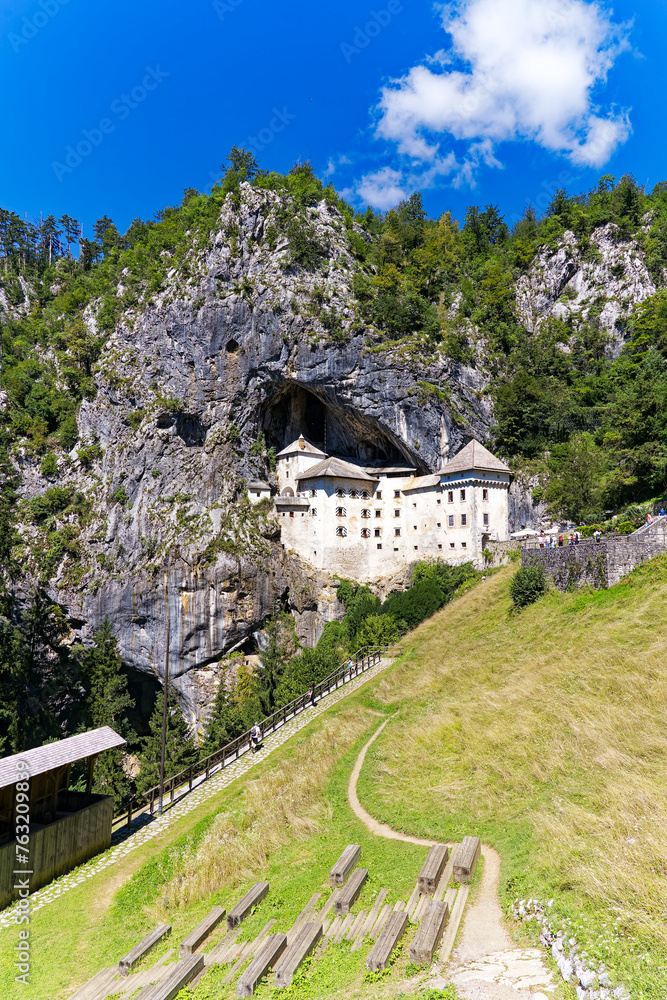 Beautiful impressive medieval castle with cave in the background at Slovenian village of Predjama on a sunny summer day. Photo taken August 11th, 2023, Predjama, Slovenia.