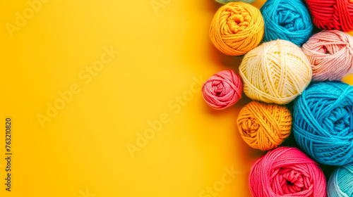 Colorful yarn balls on yellow background
