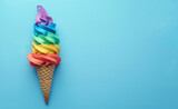 Rainbow ice cream cone on pastel blue background