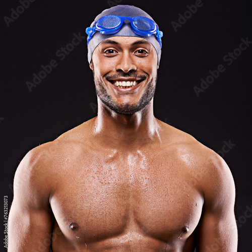 Studio, swimmer and man smile for portrait, sport and workout for training and exercise for body. Athlete, adult and male person withs strength, professional and champion in black background photo