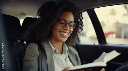 Beautiful business woman is using a smart phone and smiling while sitting on back seat in the car © standret