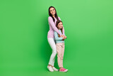 Full length photo of cute adorable mommy small girl wear casual outfits embracing isolated green color background