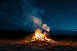 Crackling bonfire with smoke rising into a clear night sky filled with stars