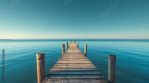 A sunlit pier extending into calm waters  its posts forming converging lines towards the distant horizon