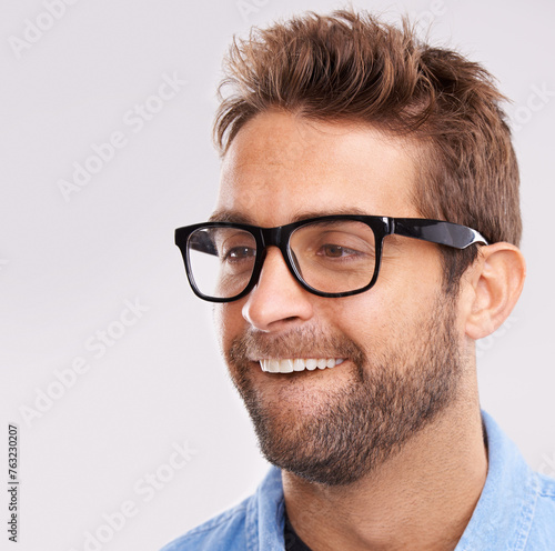 Silly face, nerd and man with glasses, happiness and facial expression on a grey studio background. Model, eyewear and person with goofy guy and reaction with character and quirky with comedy or joke © Mariusz S/peopleimages.com