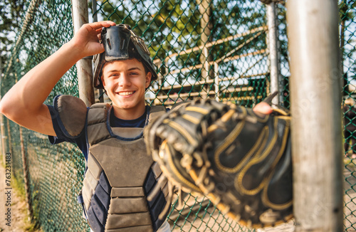 Young teen boy play baseball on a playground wearing catcher clothes