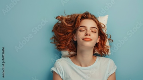 a young woman sleeping on pillow isolated on pastel blue colored background Sleep deeply peacefully rest. Top above high angle view photo portrait of satisfied .senior wear blue shirt 