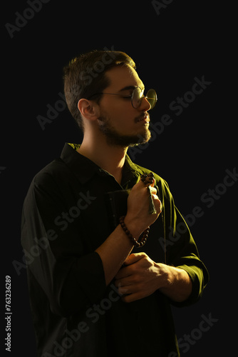 Thoughtful young man holdin...