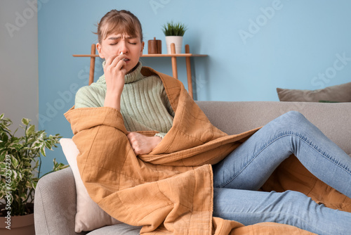 Ill young woman using nasal...