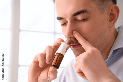 Ill businessman using nasal...
