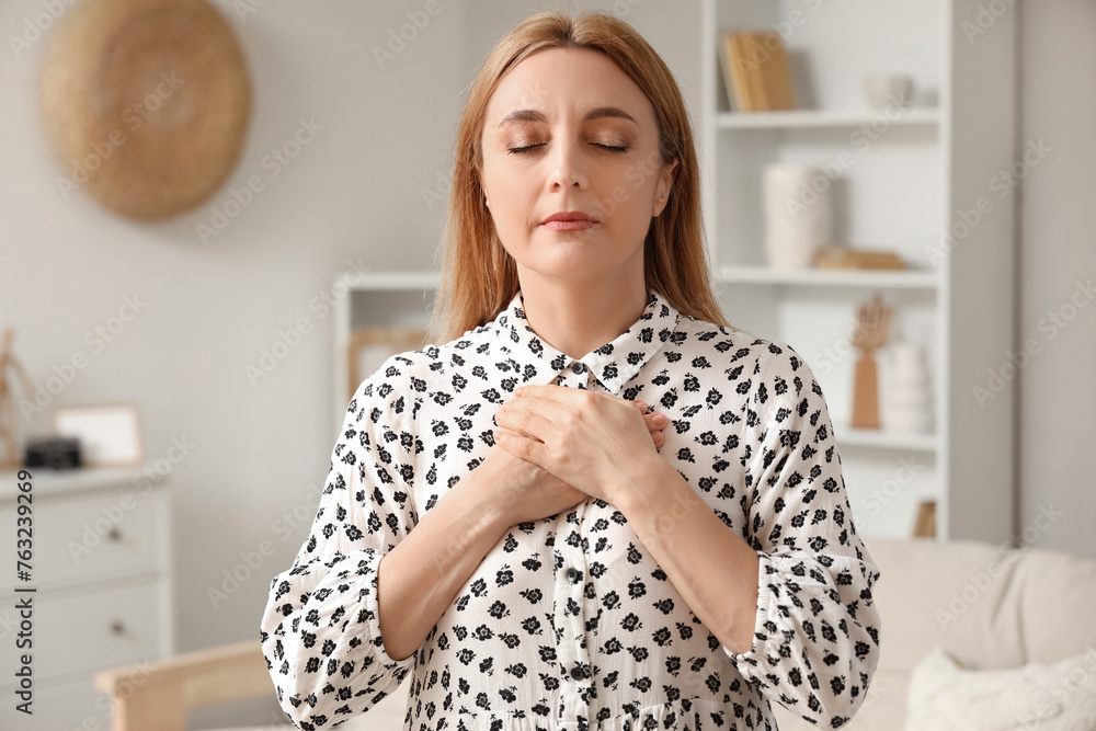 Mature woman praying at home Mature woman praying at home
