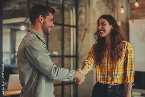 Man and woman shaking hands closing deal in an office