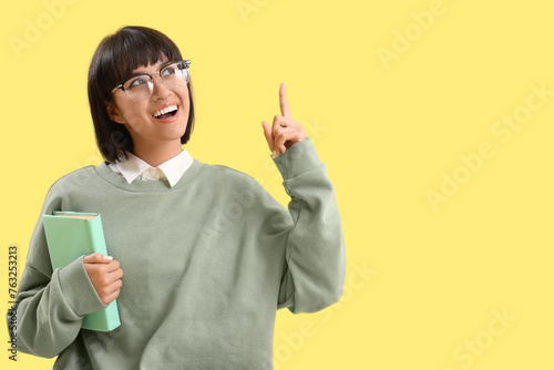 Young woman with book point...