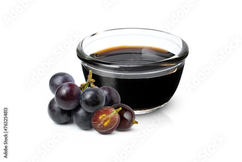 black grape and grape molasses in glass bowl isolated on white background.