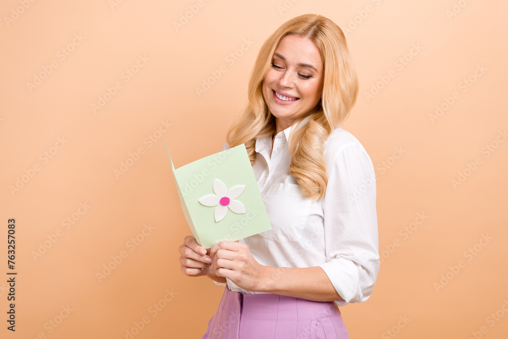 Photo of good mood sweet lady dressed white shirt reading greetings postcard empty space isolated beige color background Photo of good mood sweet lady dressed white shirt reading greetings postcard empty space isolated beige color background