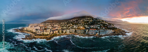 Panoramic aerial view of Bantry Bay and low cloud over Lion’s Head Mountain with Table Mountain in background at sunset, Bantry Bay, Cape Town, South Africa.