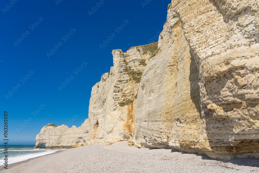 Etretat cliffs and beach in the Normandie region of France in a sunny day. Falaise d'amont chalk clliffs in the Alabaster coast.