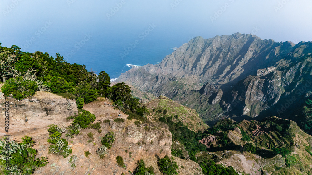 aerial drone view of a person standing on the edge of green rugged mountain ridges, North-west on Santo Antao island, Cape Verde.