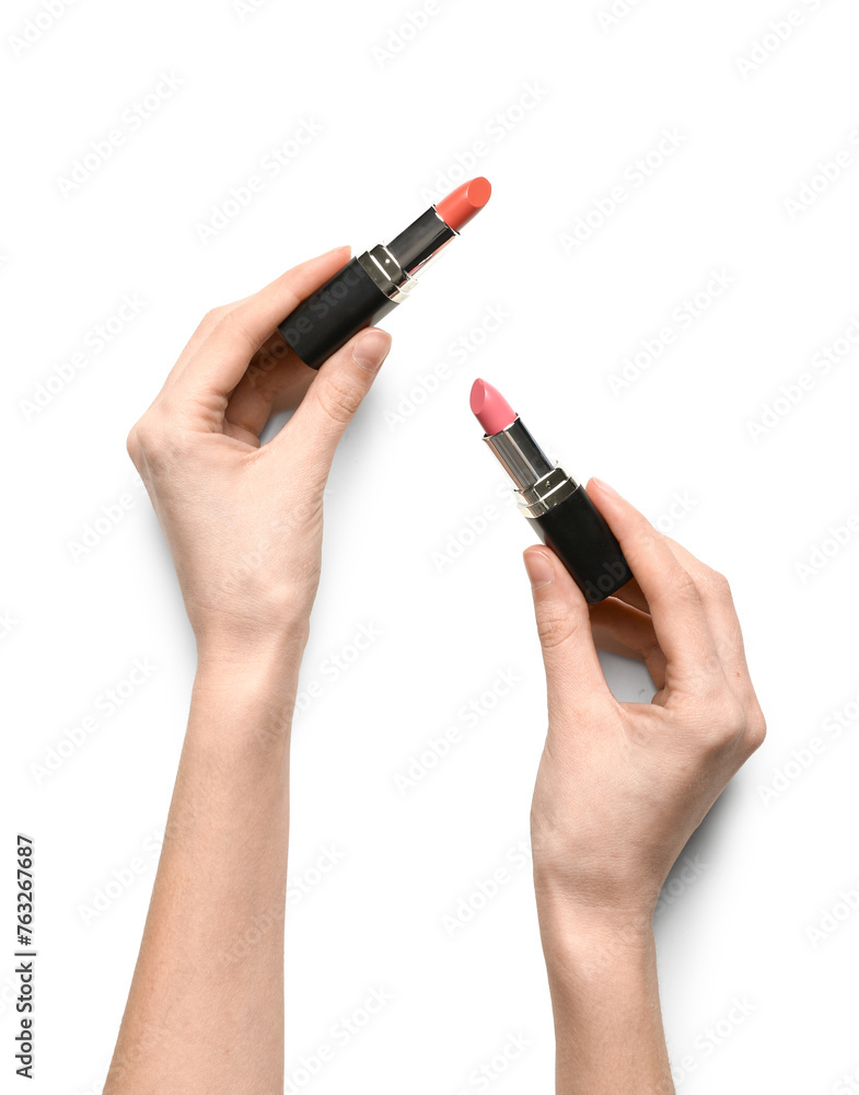 Female hands with color lipsticks on white background Female hands with color lipsticks on white background
