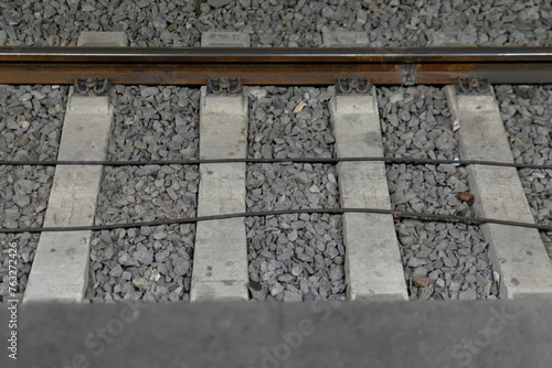 Obraz na płótnie Close-up - railway track metal rails on concrete sleepers, lie on fine gray gravel w salonie