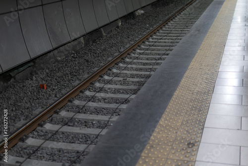 Obraz na płótnie Railway metal rails and concrete sleepers for a metro train on gray gravel inside the underground metro station w salonie