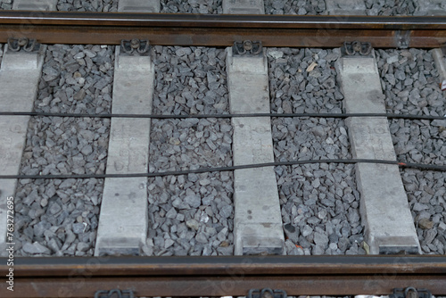 Obraz na płótnie Close-up - railway track metal rails on concrete sleepers, lie on fine gray gravel w salonie
